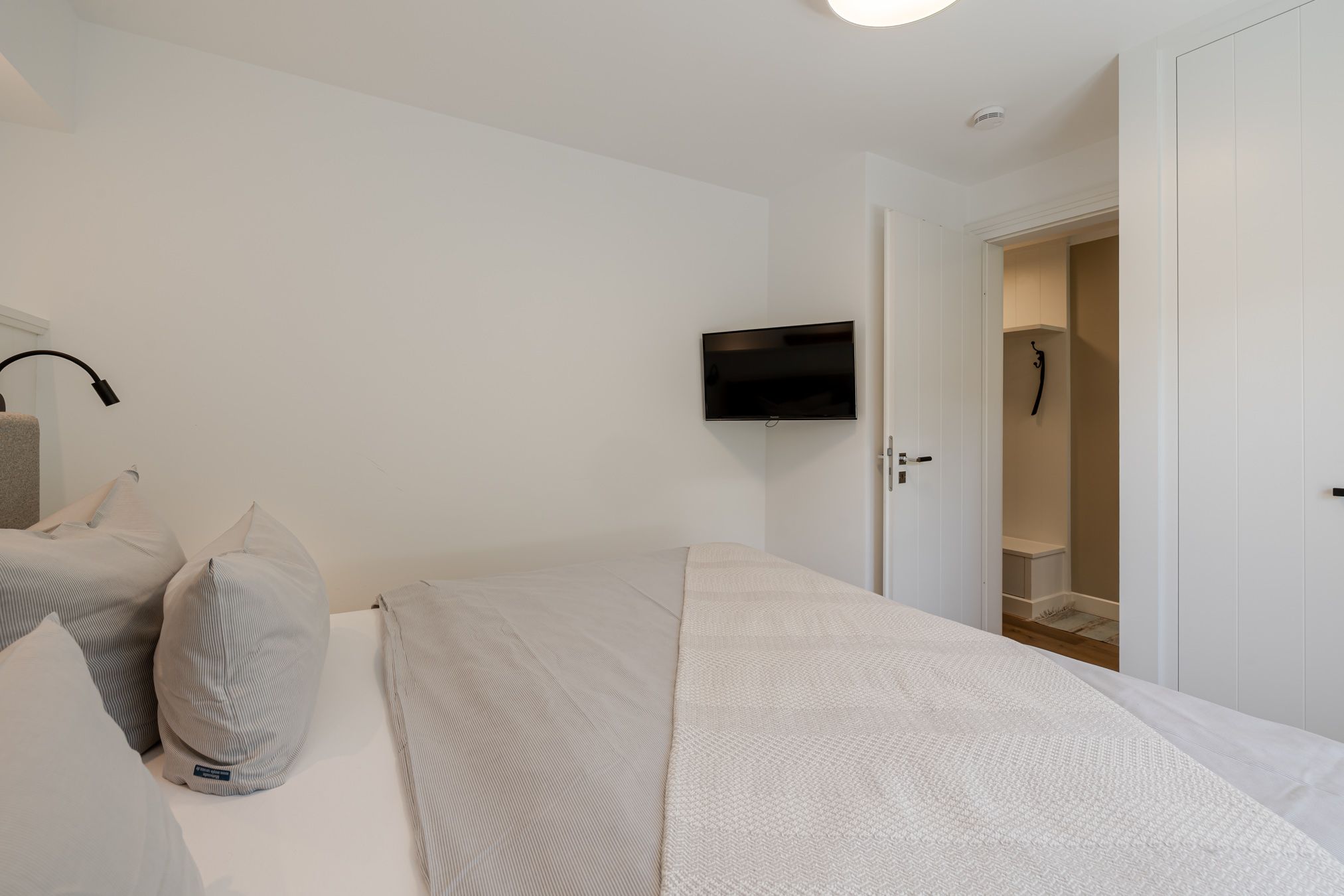 Schlafzimmer mit Stauraum und zweitem Flatscreen-TV