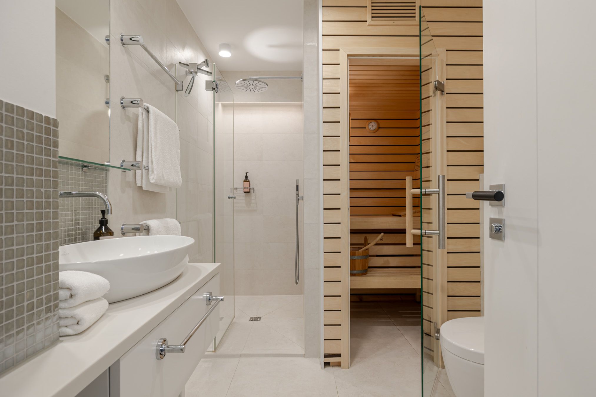 Modernes Badezimmer mit Tür zur privaten Sauna