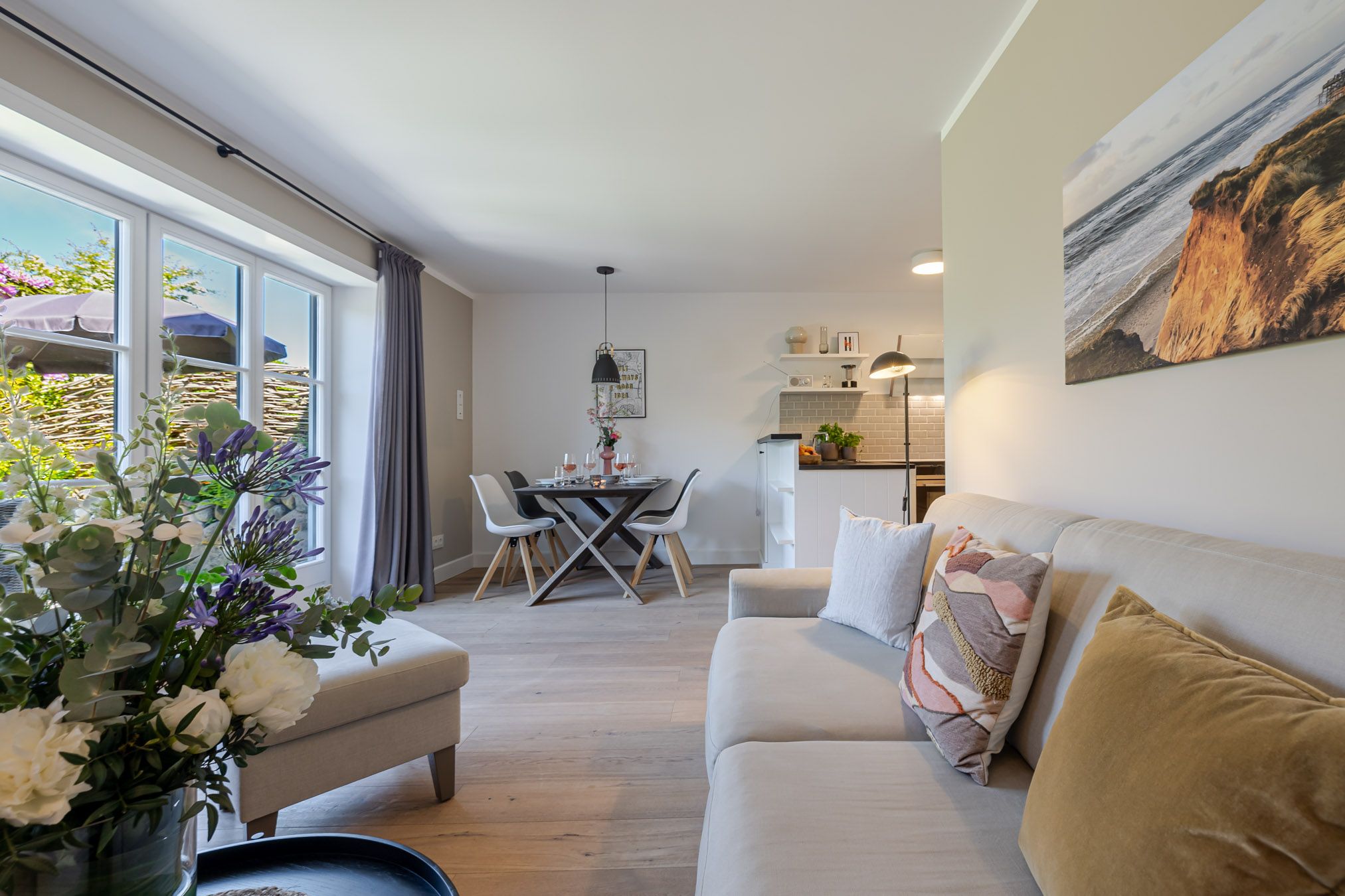 Wohnzimmer der Ferienwohnung Meersalz mit Sofa, Kamin und Terrassentür