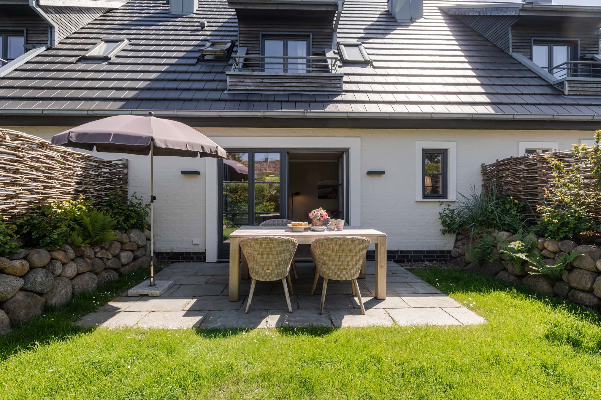 Geschützte West-Terrasse mit Gartenmöbeln und Abendsonne